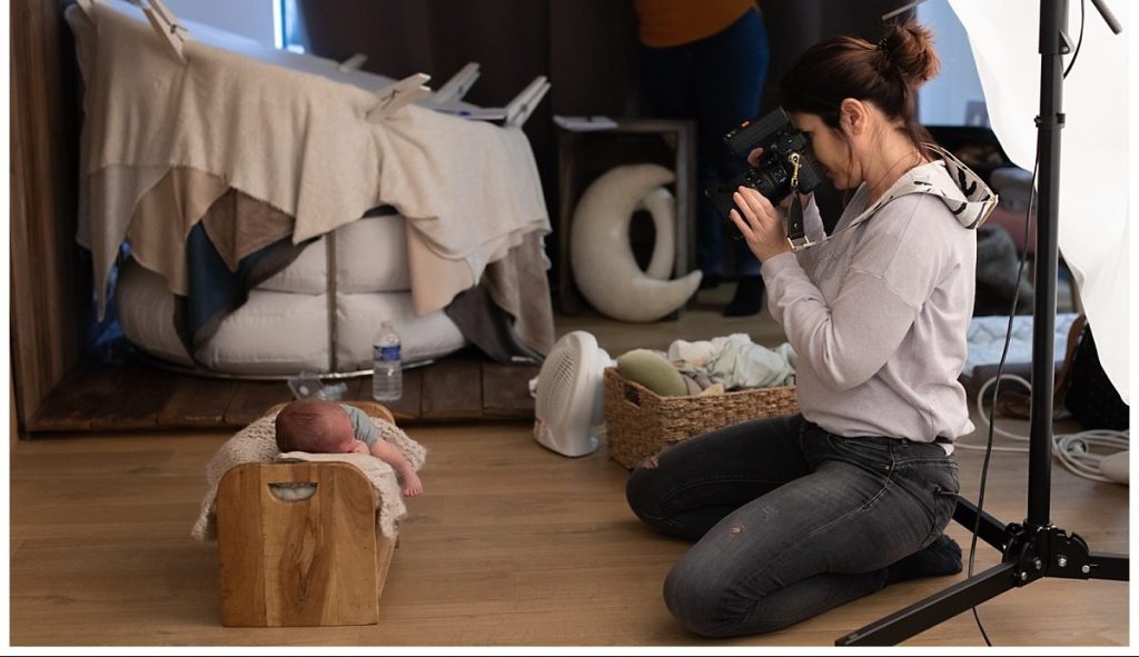 Photographe en studio réalisant une séance avec un bébé