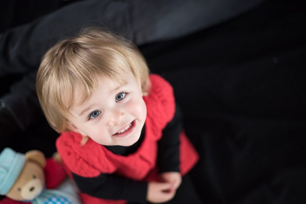 Petite fille souriant portant une robe rouge