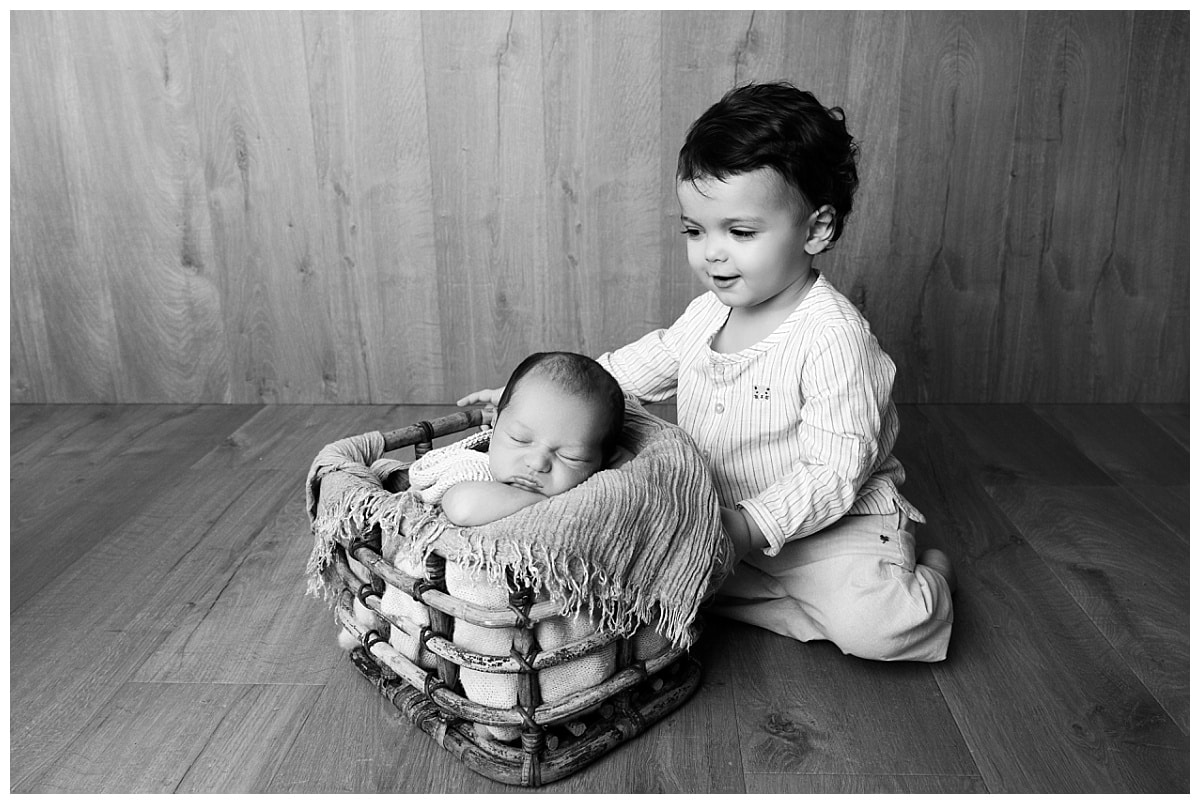 photo frère et bébé dans lit bois